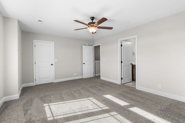 unfurnished bedroom featuring visible vents, ensuite bathroom, a ceiling fan, carpet flooring, and baseboards