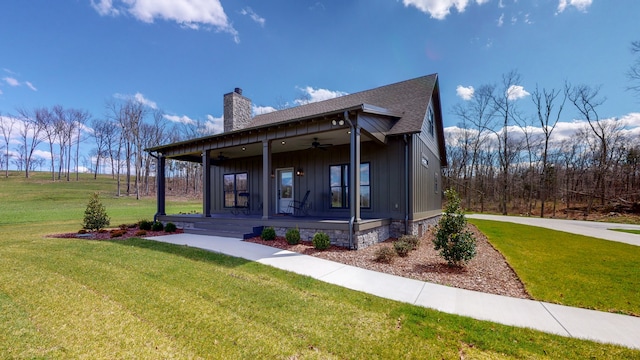 view of front of property with ceiling fan, covered porch, and a front lawn