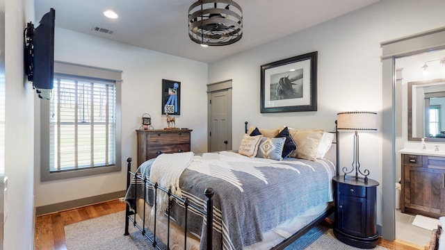 bedroom featuring hardwood / wood-style flooring and ensuite bath