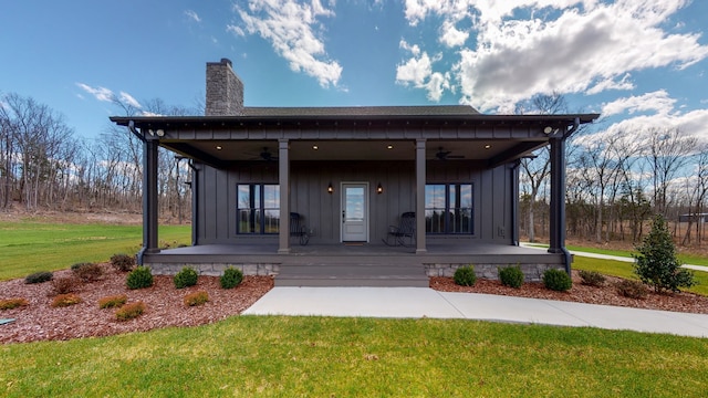 exterior space with a front lawn, ceiling fan, and a porch