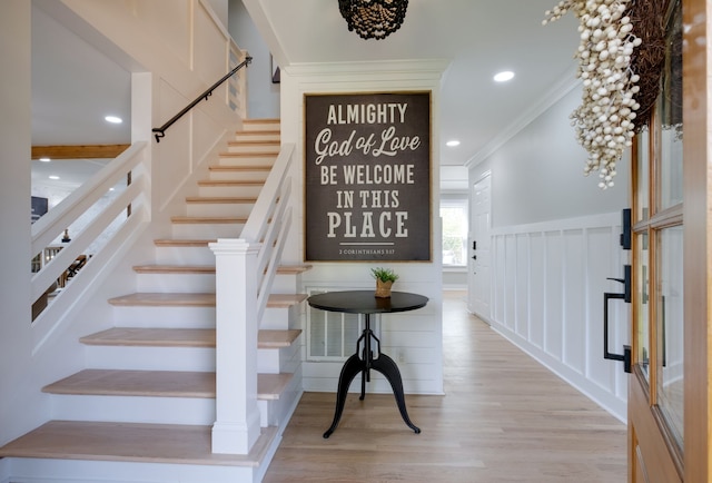 entrance foyer with light hardwood / wood-style flooring and ornamental molding