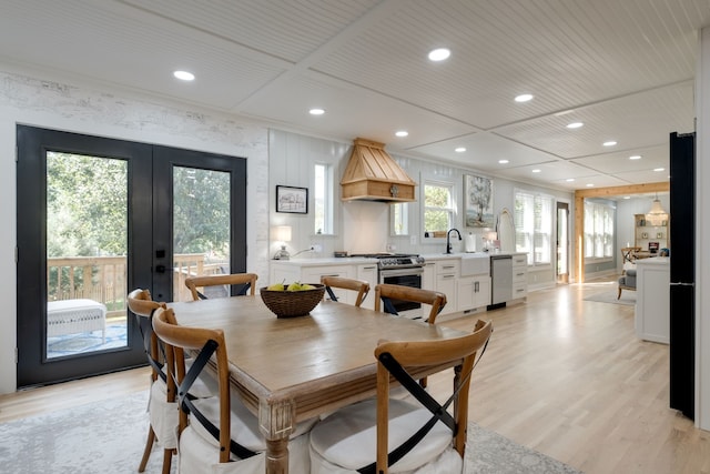 dining area with sink, light hardwood / wood-style flooring, and french doors