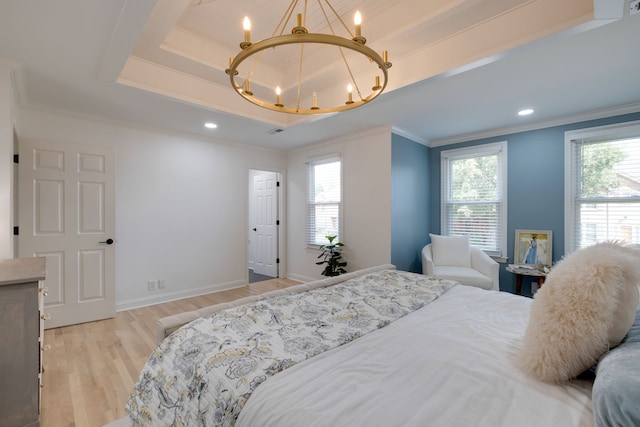 bedroom featuring a tray ceiling, a notable chandelier, ornamental molding, and light wood-type flooring