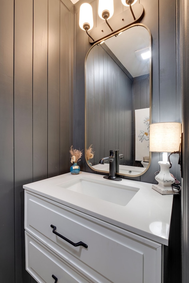 bathroom featuring wooden walls and vanity