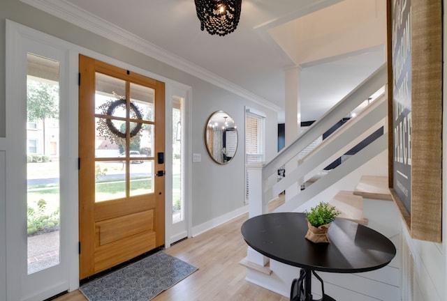 foyer entrance featuring crown molding, light hardwood / wood-style flooring, and a healthy amount of sunlight