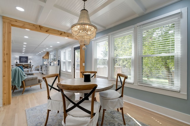 dining room featuring light hardwood / wood-style floors, a chandelier, and coffered ceiling