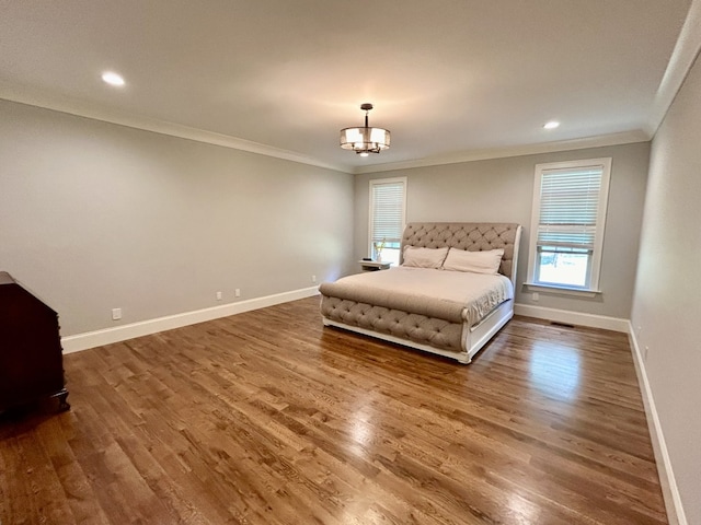 unfurnished bedroom with a notable chandelier, hardwood / wood-style floors, and ornamental molding