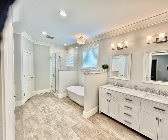 bathroom featuring crown molding, dual vanity, and a shower with shower door