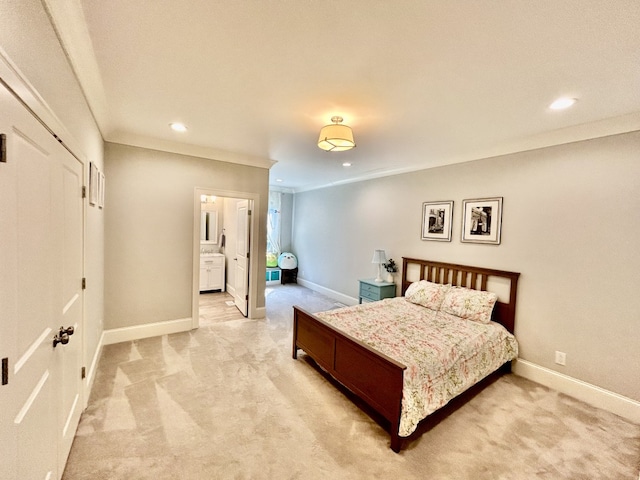 bedroom with connected bathroom and light colored carpet