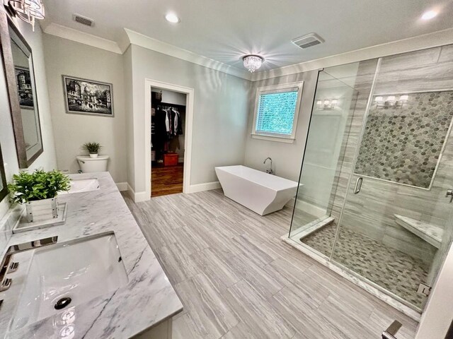 bathroom featuring dual bowl vanity, toilet, ornamental molding, and a shower with door