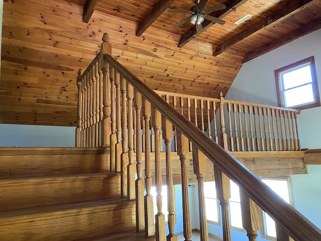 stairs featuring a high ceiling, beamed ceiling, ceiling fan, wooden ceiling, and hardwood / wood-style flooring