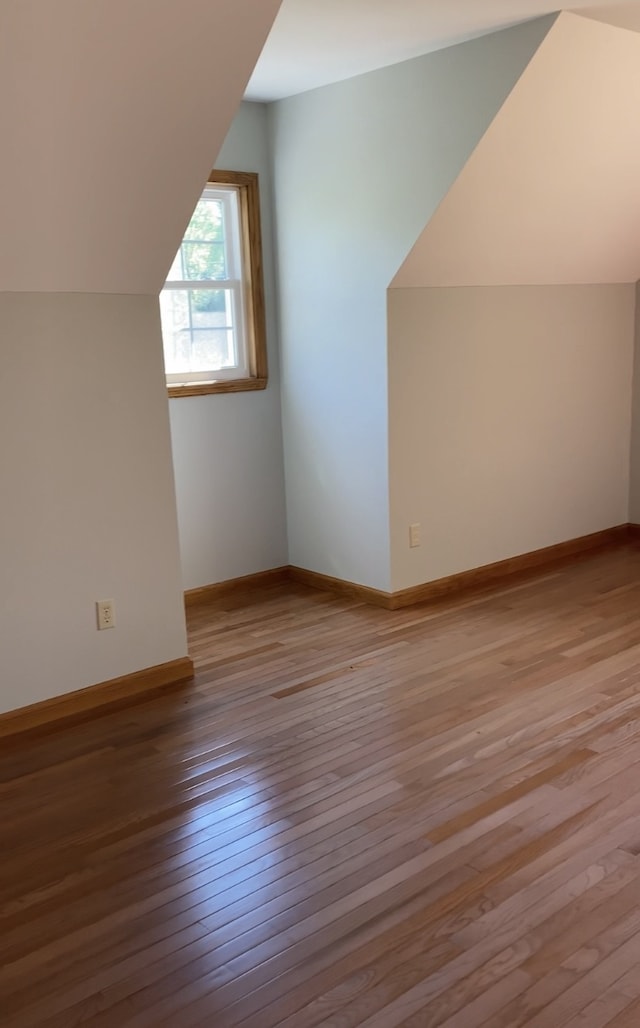 bonus room with lofted ceiling and hardwood / wood-style floors