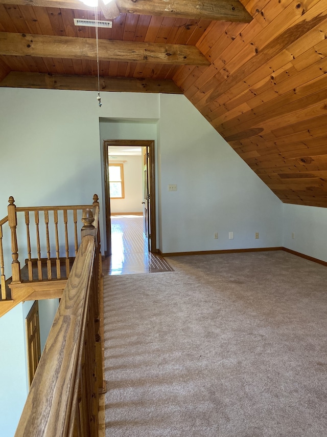 interior space featuring lofted ceiling with beams, carpet, and wood ceiling