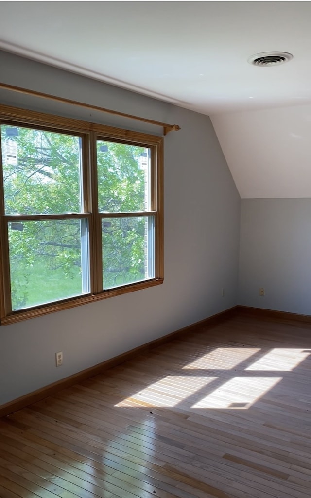 bonus room with vaulted ceiling and wood-type flooring