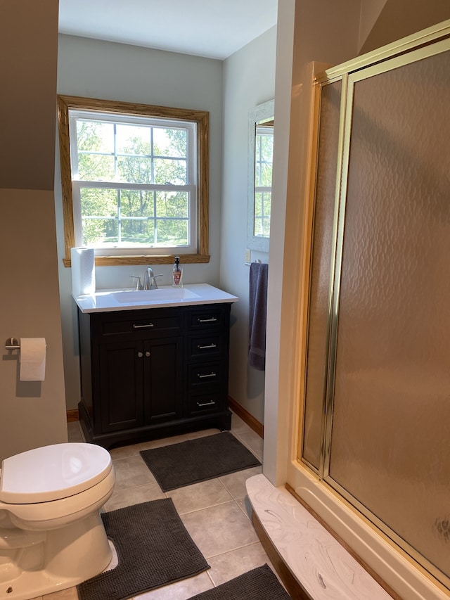 bathroom with tile patterned floors, toilet, vanity, and a shower with shower door