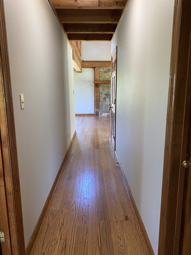 hall with beam ceiling and hardwood / wood-style floors