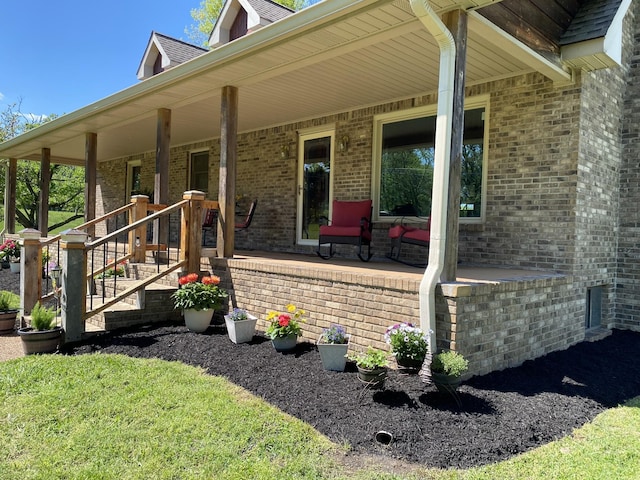 view of side of home with brick siding and a porch