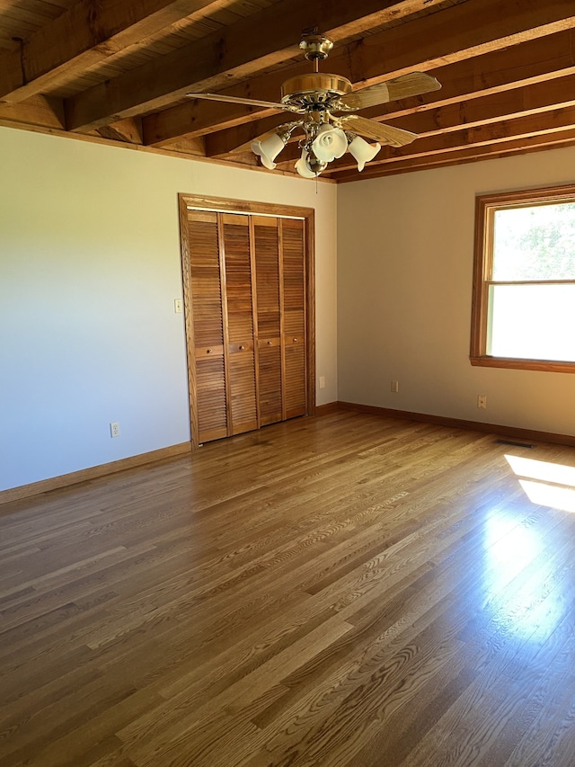 unfurnished bedroom featuring ceiling fan, beam ceiling, hardwood / wood-style flooring, and wood ceiling