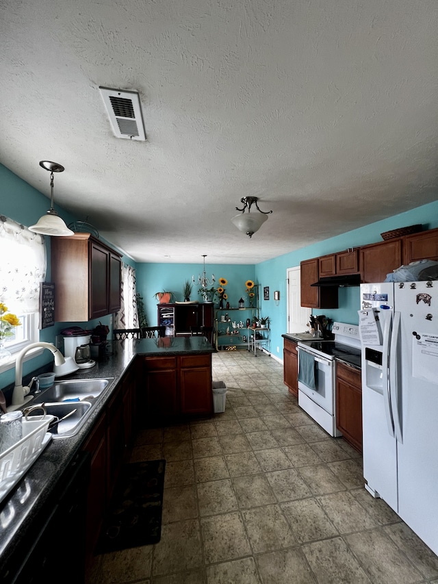 kitchen featuring sink, dark tile patterned flooring, a textured ceiling, pendant lighting, and white appliances