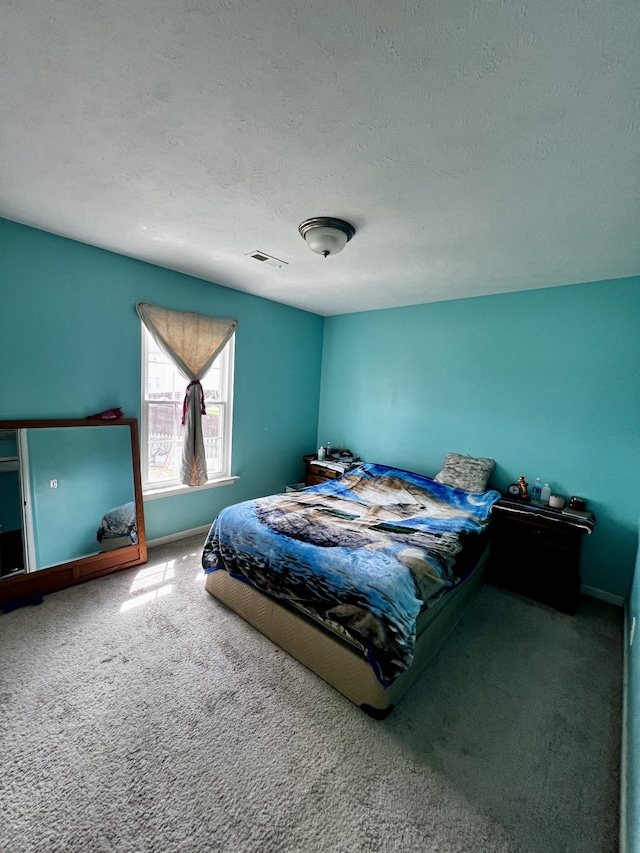 carpeted bedroom with a textured ceiling