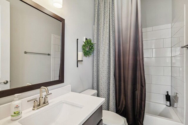 full bathroom featuring shower / bath combination with curtain, vanity, and toilet