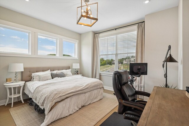 bedroom featuring hardwood / wood-style floors and an inviting chandelier