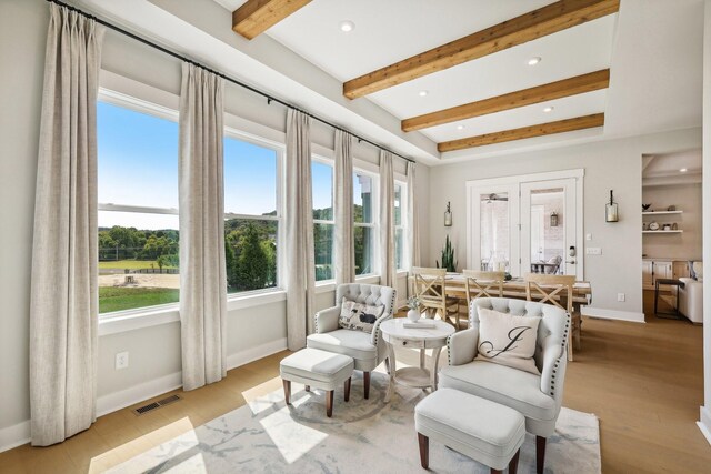 sitting room featuring light wood-type flooring and beam ceiling