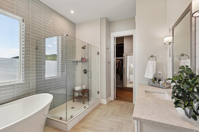 bathroom with parquet flooring, independent shower and bath, and vanity