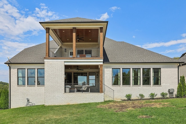 back of house with ceiling fan, a balcony, and a lawn