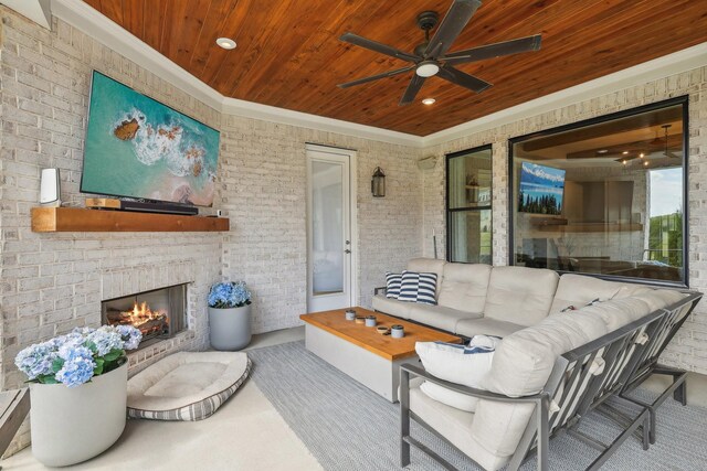 view of patio / terrace with ceiling fan and an outdoor living space with a fireplace