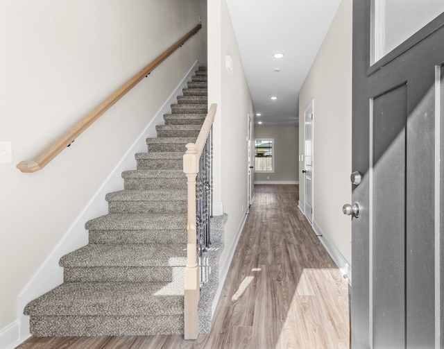 foyer featuring stairway, baseboards, wood finished floors, and recessed lighting