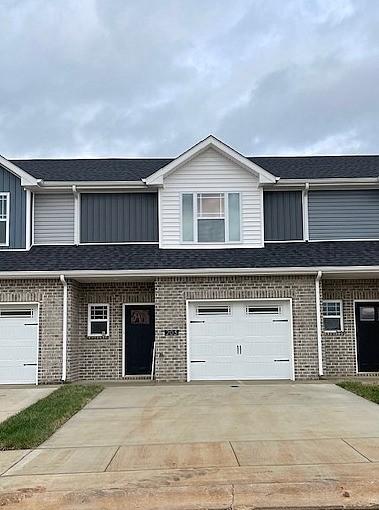 203 W Fallow Ct, Clarksville, TN 37040 - townhome / multi-family property with a garage, brick siding, concrete driveway, and board and batten siding