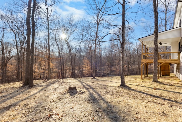 view of yard featuring ceiling fan and a deck