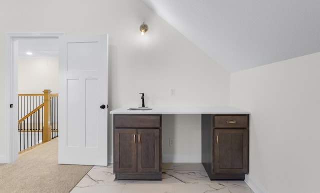 bar featuring dark brown cabinets, light colored carpet, lofted ceiling, and sink