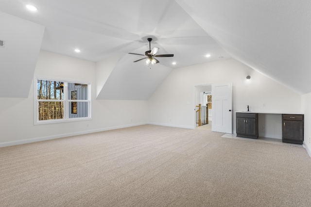 additional living space with ceiling fan, light colored carpet, and vaulted ceiling