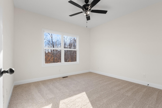 carpeted spare room with ceiling fan