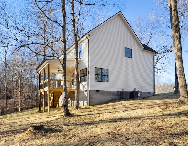 view of side of property featuring ceiling fan, central AC unit, and a deck