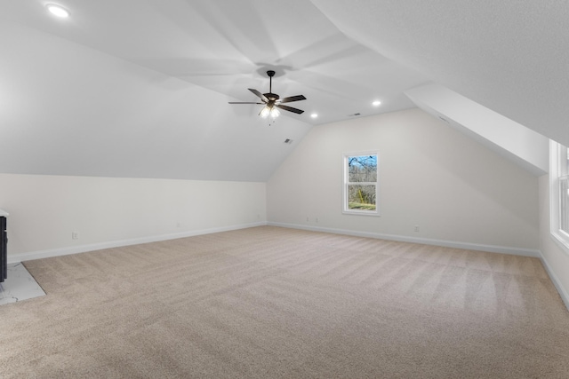 additional living space featuring ceiling fan, light carpet, and lofted ceiling