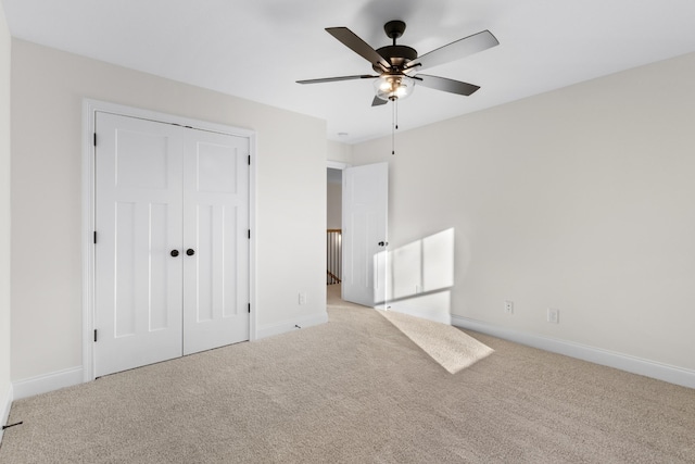 unfurnished bedroom with ceiling fan, light colored carpet, and a closet