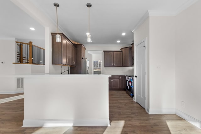 kitchen with sink, crown molding, hardwood / wood-style flooring, appliances with stainless steel finishes, and dark brown cabinetry