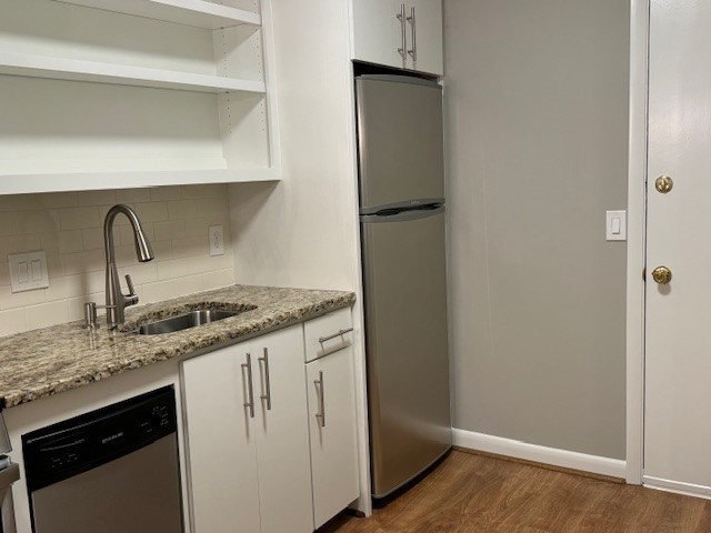 kitchen featuring hardwood / wood-style flooring, sink, backsplash, and stainless steel appliances