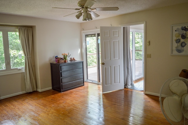 foyer entrance featuring hardwood / wood-style floors, ceiling fan, and a textured ceiling