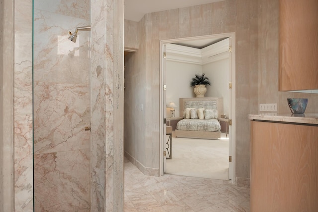 ensuite bathroom featuring marble finish floor, a tile shower, connected bathroom, and vanity