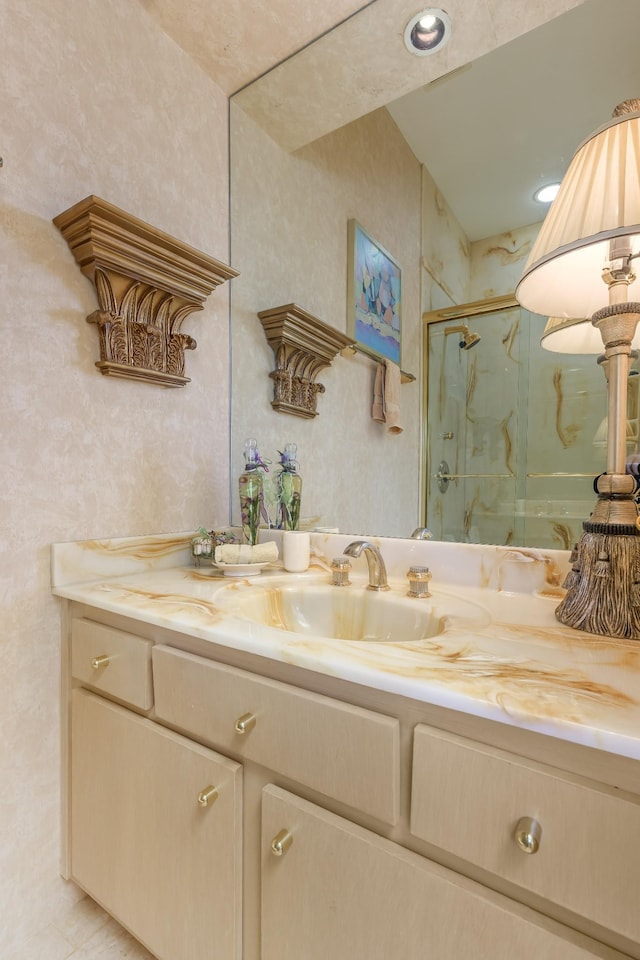 bathroom with a marble finish shower and vanity