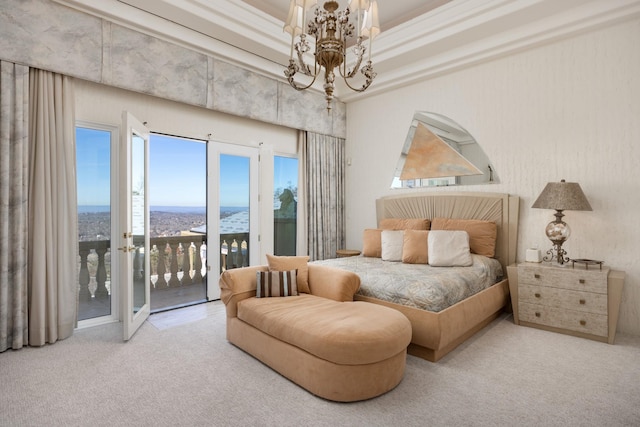 bedroom featuring access to outside, a water view, carpet flooring, and an inviting chandelier