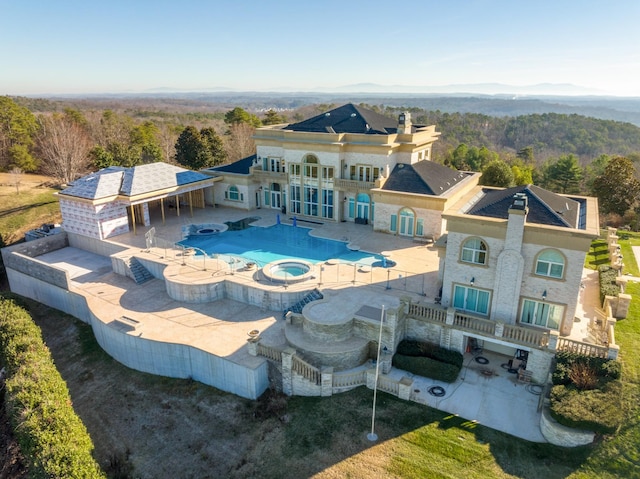 back of property with a patio area and a pool with connected hot tub