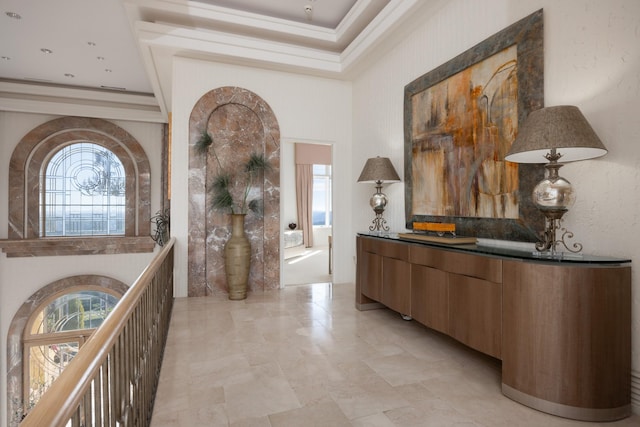 corridor featuring a high ceiling and crown molding