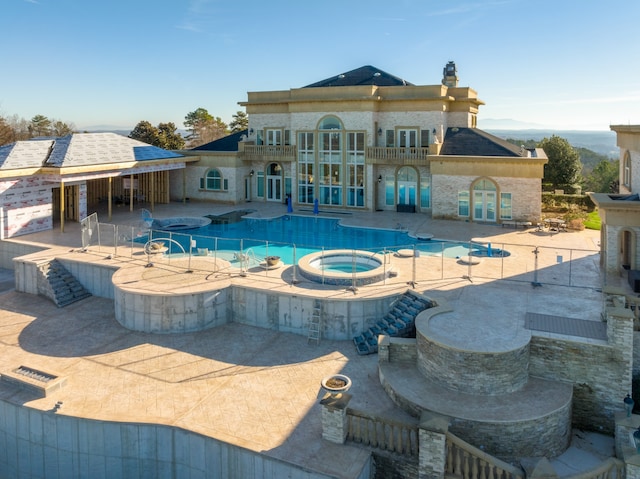 view of swimming pool featuring a patio area and an in ground hot tub