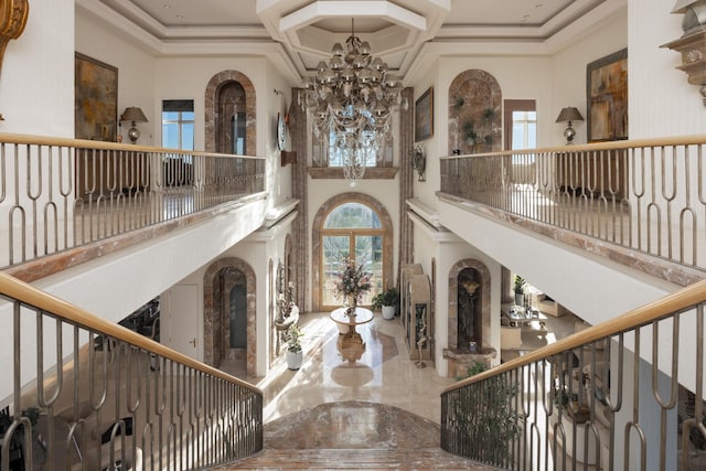 interior space featuring a chandelier, a wealth of natural light, and a high ceiling