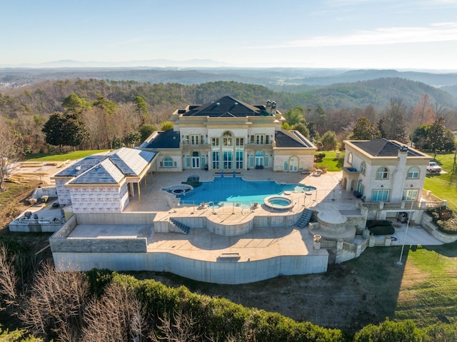 exterior space featuring a patio area and a pool with connected hot tub